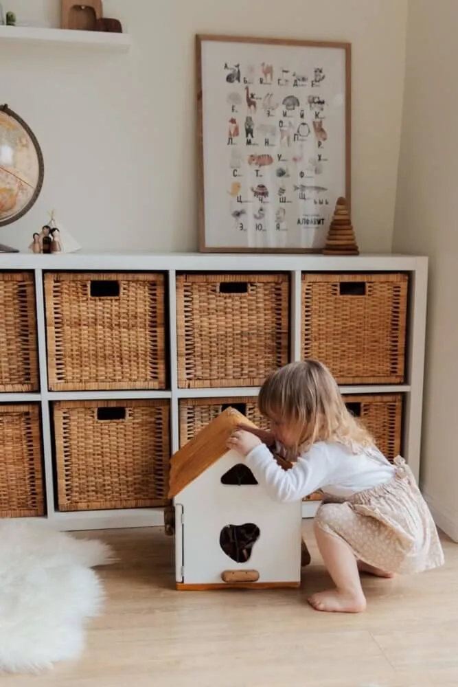 Little girl playing with dolls House